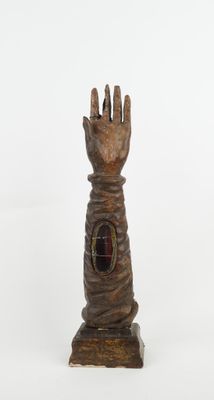 une sculpture en bois représentant une main percée d'un trou au milieu