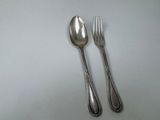 two spoons and a fork on a white table
