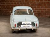 a small blue car parked in front of a brick wall