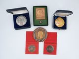 three medals and a medal in a case on a white surface
