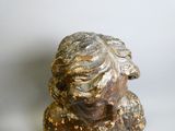 une statue représentant un homme barbu posée sur une surface blanche