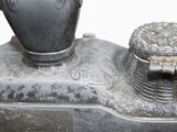a metal object with a vase on top of it
