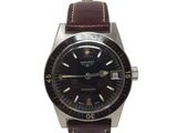 une photo d'une montre avec un cadran noir et un bracelet en cuir marron