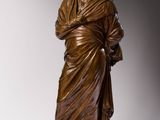 une statue en bronze représentant un homme avec une robe sur la tête
