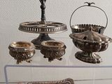 a glass display case with silver objects on it