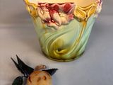 a small vase with a flower on it next to a small flower