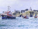 many boats that are in the water near a lighthouse