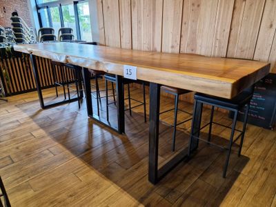 une grande table en bois avec deux tabourets devant