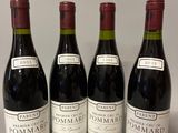 quatre bouteilles de vin sont alignées sur une table