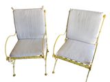une paire de chaises de jardin en métal blanc et doré, avec des coussins blancs