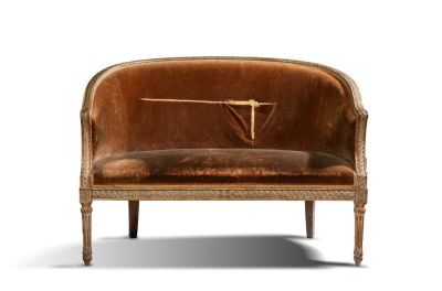a brown velvet couch with a clock on it