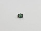 a green tourmaline gems on a white surface
