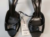 the woman is wearing a pair of black shoes with a price tag on it