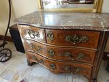 une commode au plateau en marbre, surmontée d'un miroir