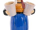 a figurine of a woman holding two cups of coffee