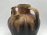 a brown vase that is sitting on a white surface
