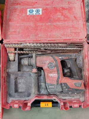 une boîte rouge contenant une perceuse et un marteau