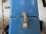 a blue suitcase sitting on top of a wooden table
