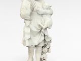 une statue représentant un garçon tenant un bébé et une pomme