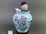 une figurine représentant un garçon assis dans un vase