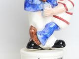 a figurine of a boy and a boy playing a musical instrument