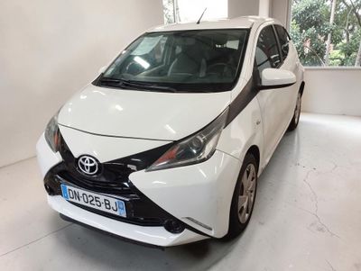une Toyota AY blanche garée dans un garage
