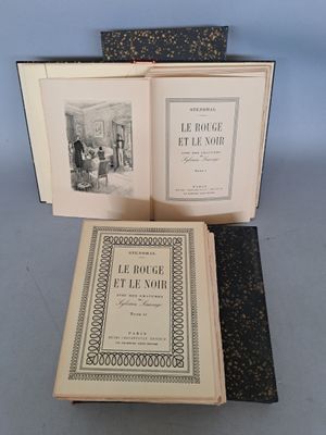 trois livres ouverts posés sur une table l'un à côté de l'autre