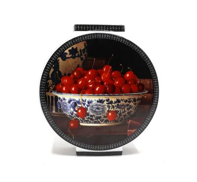un bol de cerises posé sur une table, avec une carte du monde en arrière-plan