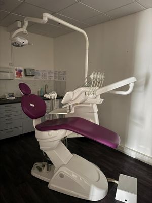 un fauteuil de dentiste avec un siège violet dans une pièce