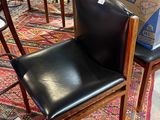 un fauteuil en cuir noir posé sur un tapis au milieu d'une pièce