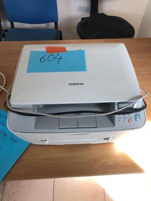 a printer sitting on top of a table with a note attached to it