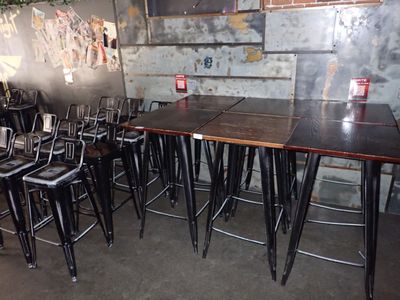 des tables et des tabourets dans une pièce dont les murs sont recouverts de graffitis
