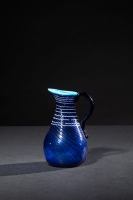 a blue vase sitting on a table with a black background
