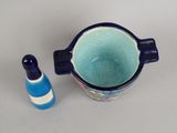 a blue and white cup and a blue bottle on a table