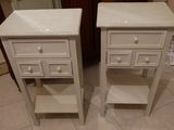 deux tables de chevet blanches avec des tiroirs, placées de chaque côté