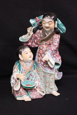 a figurine of a woman and a child sitting on a black background
