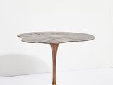 une table ronde avec un piètement en métal et un plateau en marbre