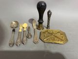 a lot of silverware on a table with a spoon, fork and knife holder