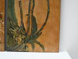 two paintings of flowers on a shelf in a room