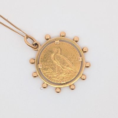 une image représentant un pendentif en forme de pièce d'or sur lequel figure un oiseau