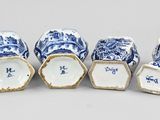six blue and white porcelain vases are lined up on a table