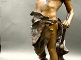 a bronze statue of a man holding something in his hand