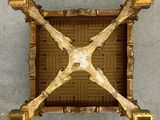 an overhead view of a gold metal structure on a concrete surface
