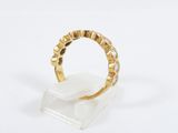 a gold and diamond ring on a clear stand