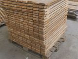 plusieurs piles de planches de bois empilées les unes sur les autres dans un entrepôt
