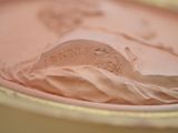 a close up of a plate with a pink frosting on it