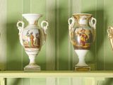 quatre vases posés sur une étagère devant un mur vert