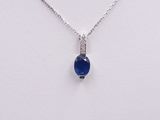 a close up of a necklace with a blue stone on it