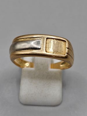 a close up of a gold and silver ring on a stand