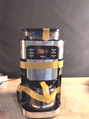 une cafetière argentée et noire posée sur une table en bois